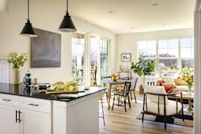 a kitchen and living room with a table and chairs