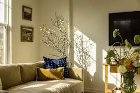 a living room with a couch and a vase of flowers