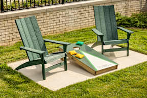 Two green chairs and a table with a book on it.