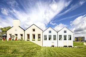 A white house with a large front yard.