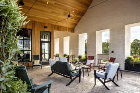 a covered patio with chairs and tables and windows