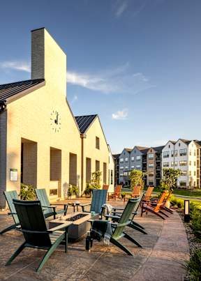 A sunny day at the outdoor seating area of a building with a clock on the side.