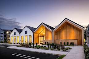 A modern house with a white exterior and wooden sidings.