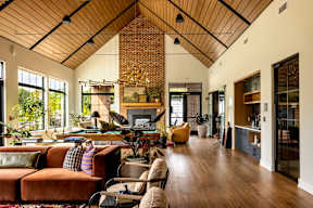 A living room with a brown couch and a wooden ceiling.