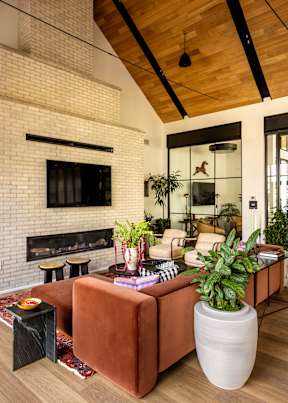 A living room with a brown couch and a fireplace.
