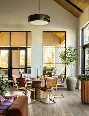 A modern dining room with a wooden table and chairs.