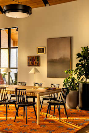 A dining room with a table and chairs.