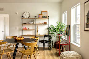 A dining room with a round table and chairs.