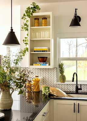 A kitchen with a black counter top and white cabinets.