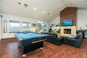 a living room with a pool table and a fireplace
