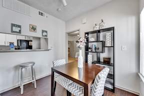 a dining room with a wooden table and chairs and a kitchen with a counter top
