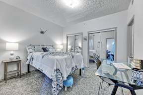 a bedroom with a bed and a glass desk