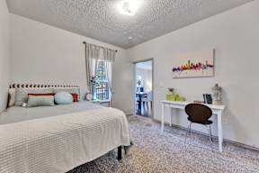 a bedroom with a bed and a desk with a chair