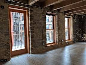 A room with wooden floors and brick walls.