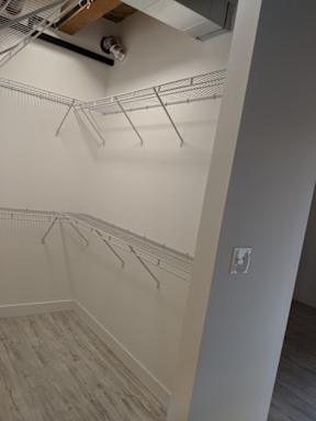 A white wall with a shelf and a light fixture.