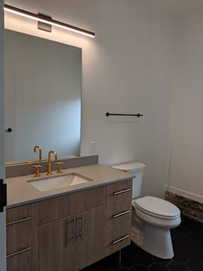 A white toilet sits next to a sink in a bathroom.