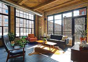 A living room with a black couch and a wooden table.