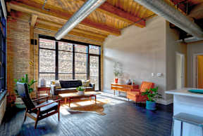 A living room with a wooden floor and a large window.