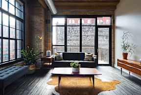 A living room with a couch, a table, and a window.
