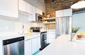 A modern kitchen with white cabinets and stainless steel appliances.