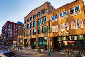 A street view of a city with a building that has a sign that says "Swig".