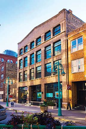 A street view of a building with a green light on the sidewalk.
