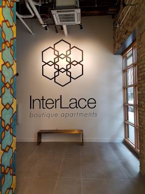 A wall with a logo that says InterLace boutique apartments.