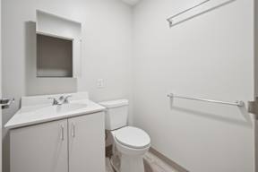 A white bathroom with a toilet, sink, and shower.