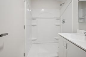 A white bathroom with a walk in shower.