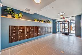 A hallway with a row of mailboxes on the wall.
