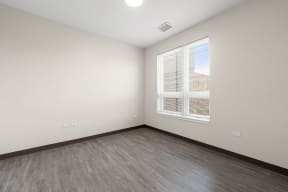 an empty room with wood floors and a window