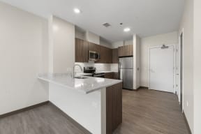 a kitchen with a marble counter top and a stainless steel refrigerator