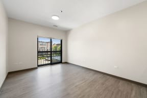 an empty living room with a door to a balcony