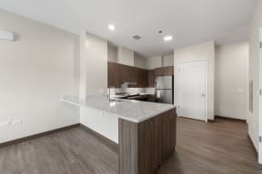 a kitchen with a marble counter top and a refrigerator