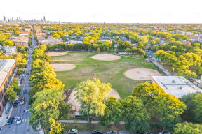 an aerial view of a park with a city in the background
