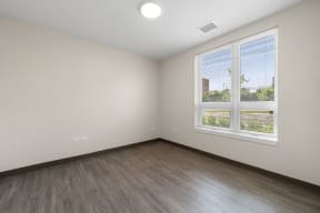 an empty room with wood floors and a window