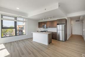 A modern kitchen with wooden cabinets and a white island.