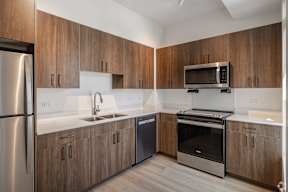 A modern kitchen with wooden cabinets and stainless steel appliances.