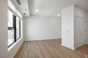 A room with a white door and a window overlooking a cityscape.
