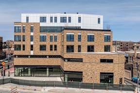 A modern building with a mix of brick and white panels.