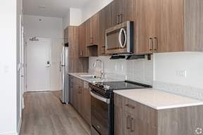 A kitchen with wooden cabinets and a black counter top.