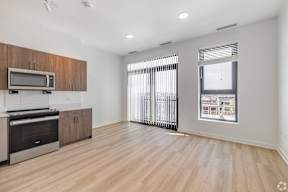 A spacious kitchen with wooden cabinets and a microwave above the stove.