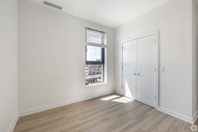 A room with a window and a wooden floor.
