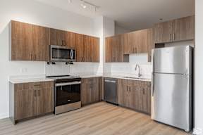 A modern kitchen with wooden cabinets and stainless steel appliances.