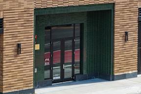 A building with a brown facade and a green tiled wall.