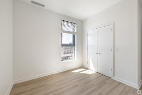 A room with a window and a wooden floor.
