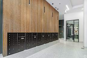A row of mailboxes are lined up against a wood grain wall.