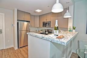 A kitchen with a marble countertop and stainless steel appliances.