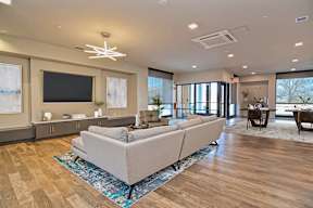 A lobby with a grey sofa and wooden flooring. Community room