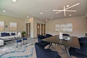 A modern community room with a dark wood table and blue chairs.